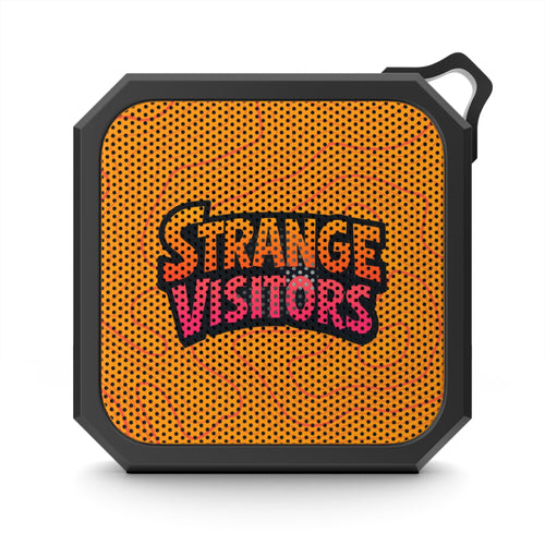 Broadcasting From The Edge speaker: a small square rugged Bluetooth speaker with a black frame, orange speaker grille and the Strange Visitors logo, with a carabiner clip