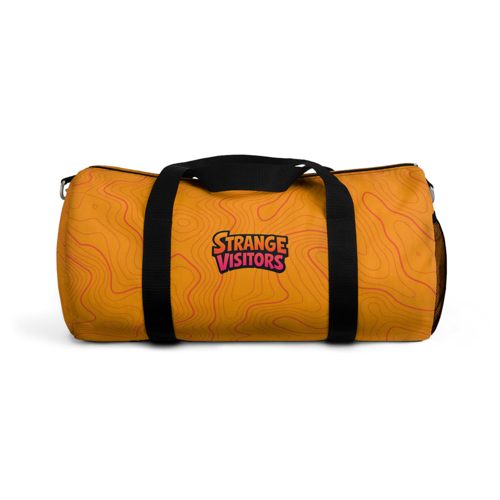 Pack For The Unknown duffel: an orange barrel-style duffel bag covered in topographic contour lines with the Strange Visitors logo, black zipper and black carry handles